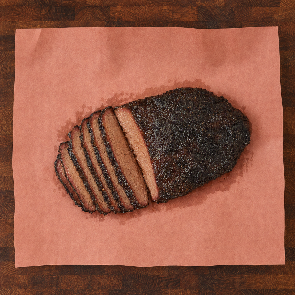 Sliced smoked brisket resting on pink butcher paper